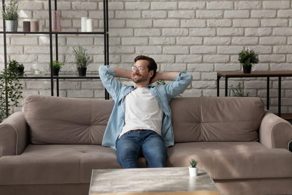 man relaxing on comfy sofa